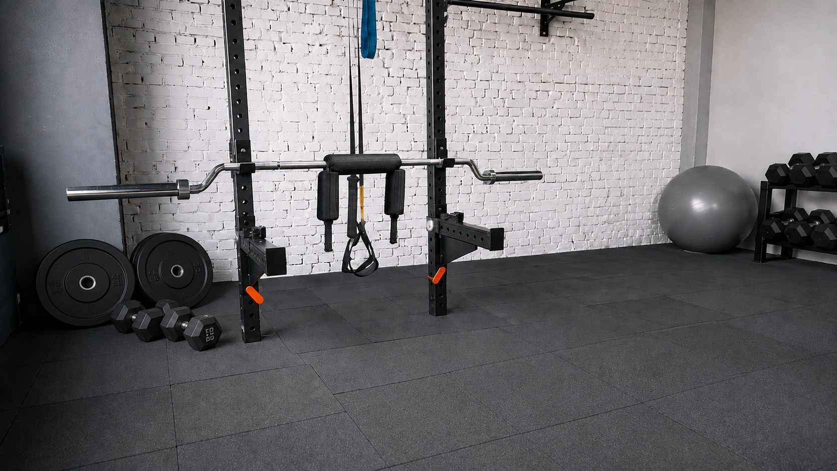 Well-equipped home gym with power rack, loaded barbell, weight plates, and dumbbells on professional flooring