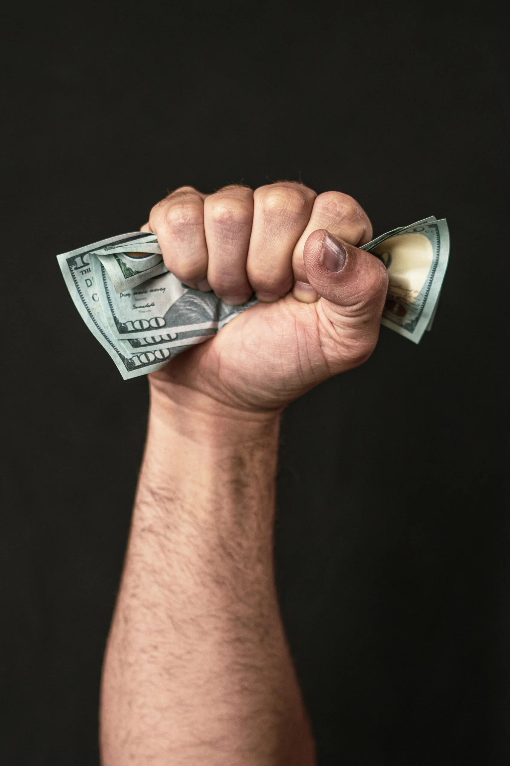 BG Budget Investment Money scaled Hand holding cash representing home gym equipment investment and budget planning