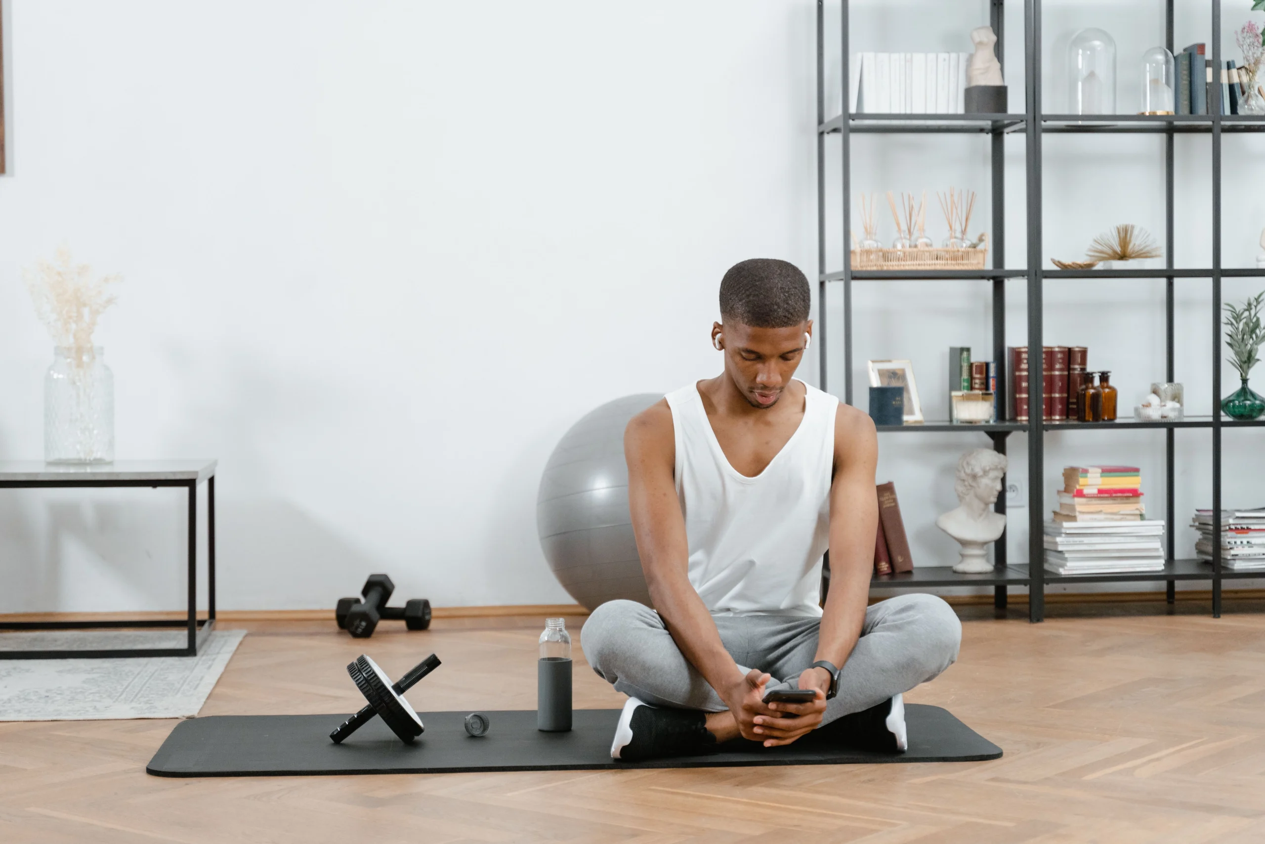 GD home gym design scaled Man using stability ball for core workout in minimalist home gym with shelving storage