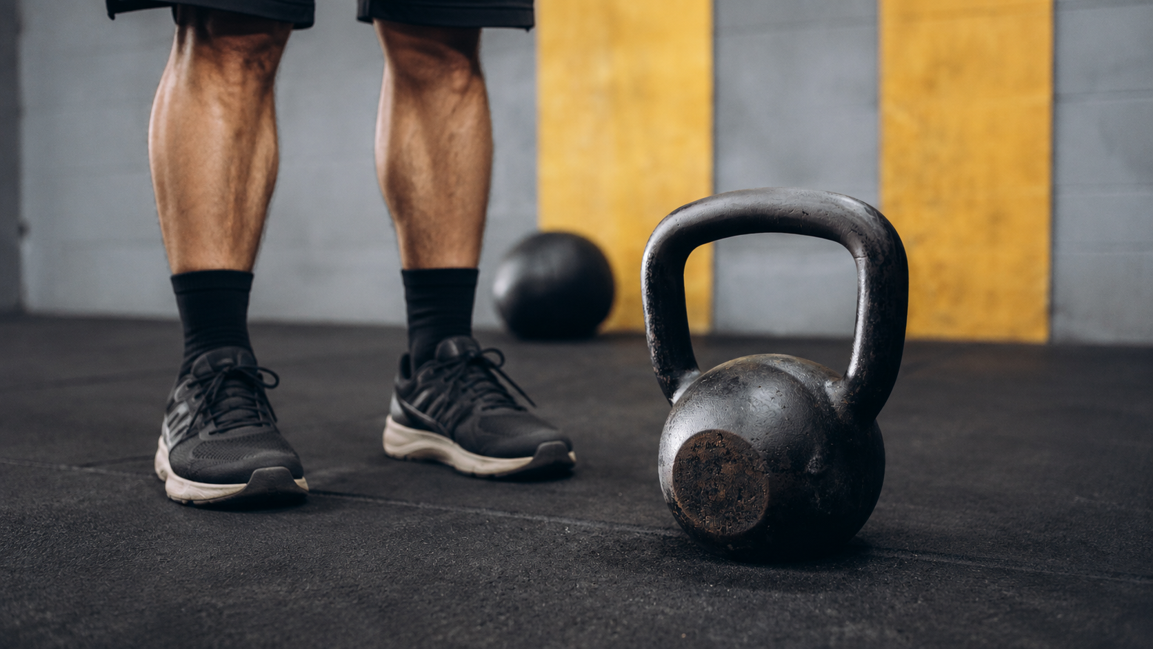 KB Full body Workout from Titan Fitness Cast iron kettlebell with athlete performing dynamic full-body exercise movement, demonstrating functional strength training and explosive power development