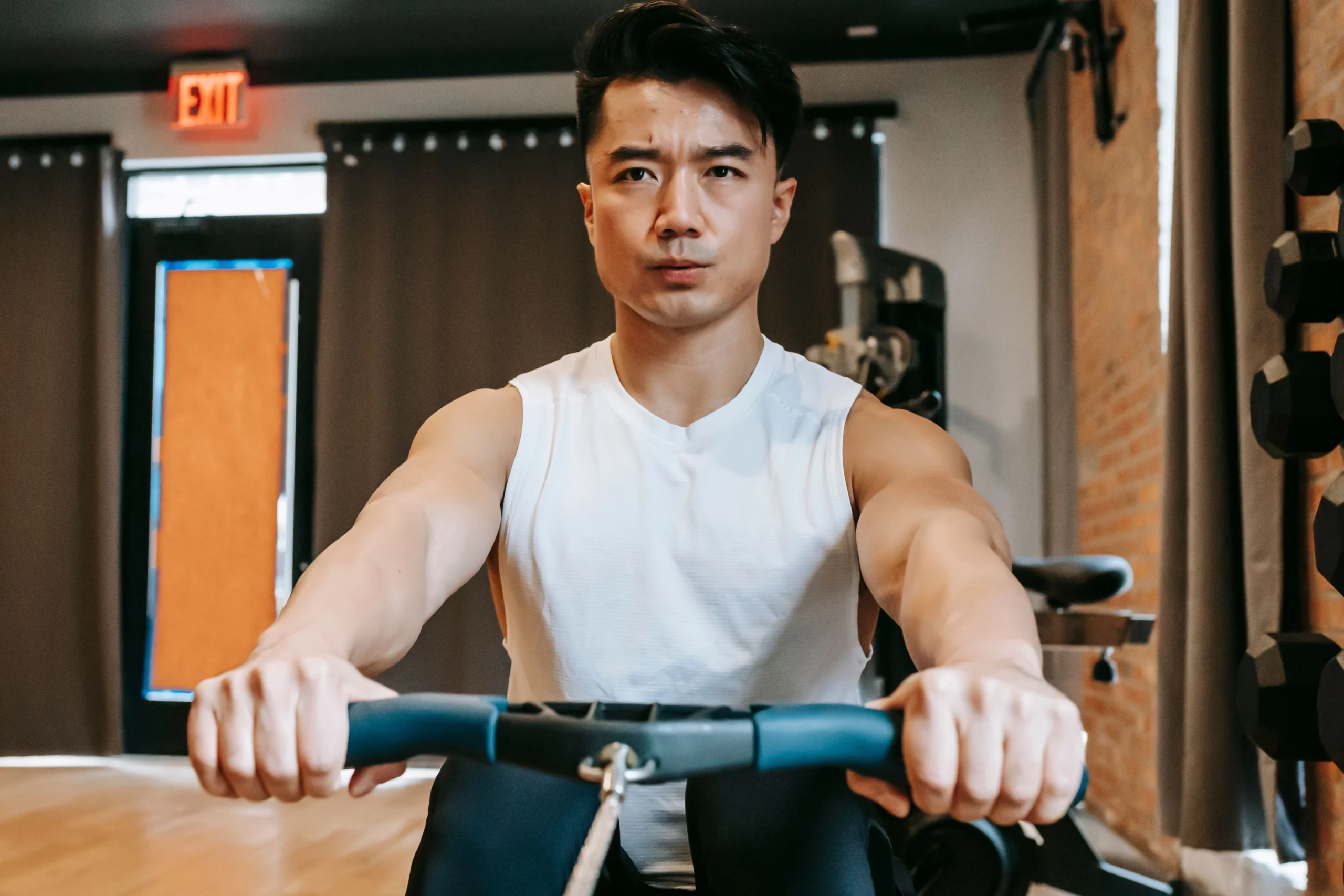 Man performing rowing machine exercise on high-performance NordicTrack equipment in gym