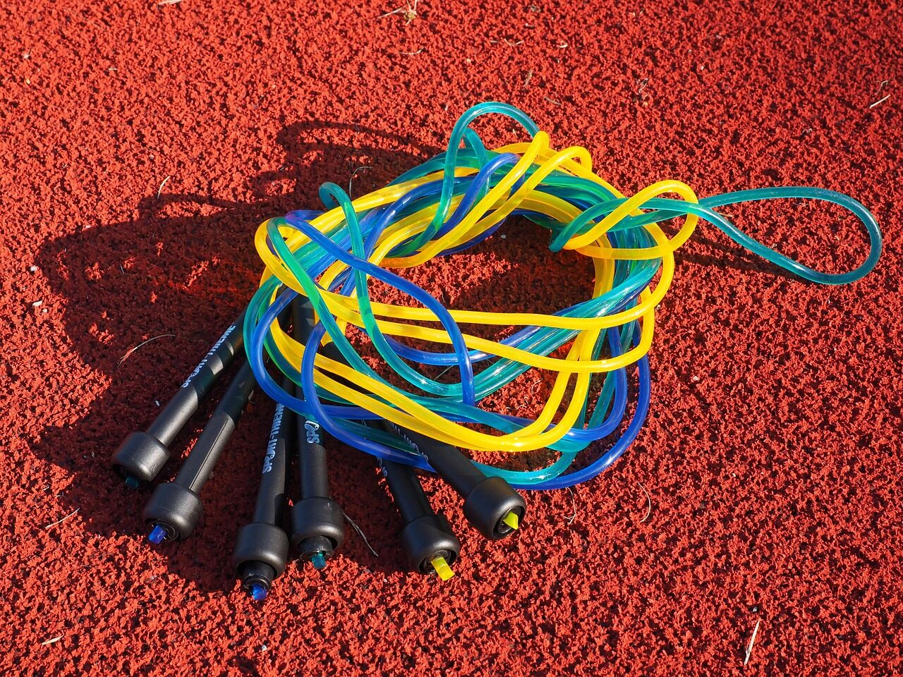 Colorful jump ropes coiled on a red running track