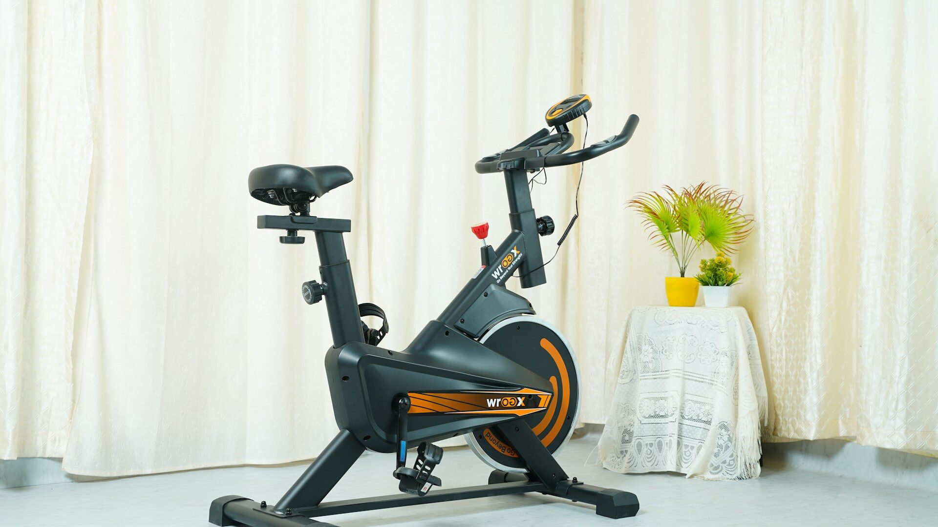 Indoor spin bike standing in a bright room with sheer curtains