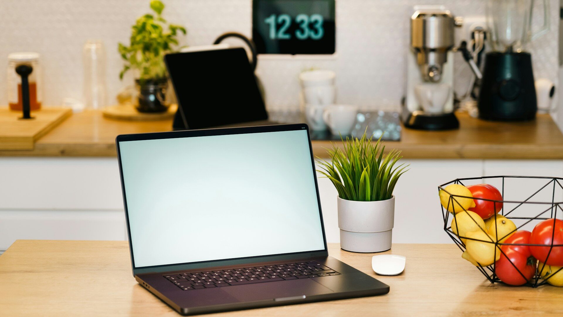 Laptop and fresh fruit bowl on a bright kitchen counter home office setup