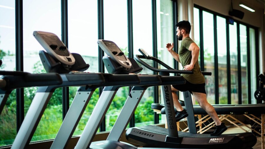 person running on an inclined treadmill during a cardio work Person running on an inclined treadmill during a cardio workout in a home gym