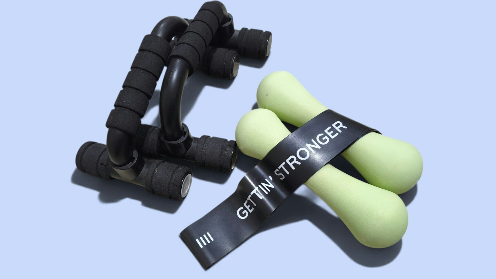 Push-up handles, light dumbbells and a resistance band arranged together