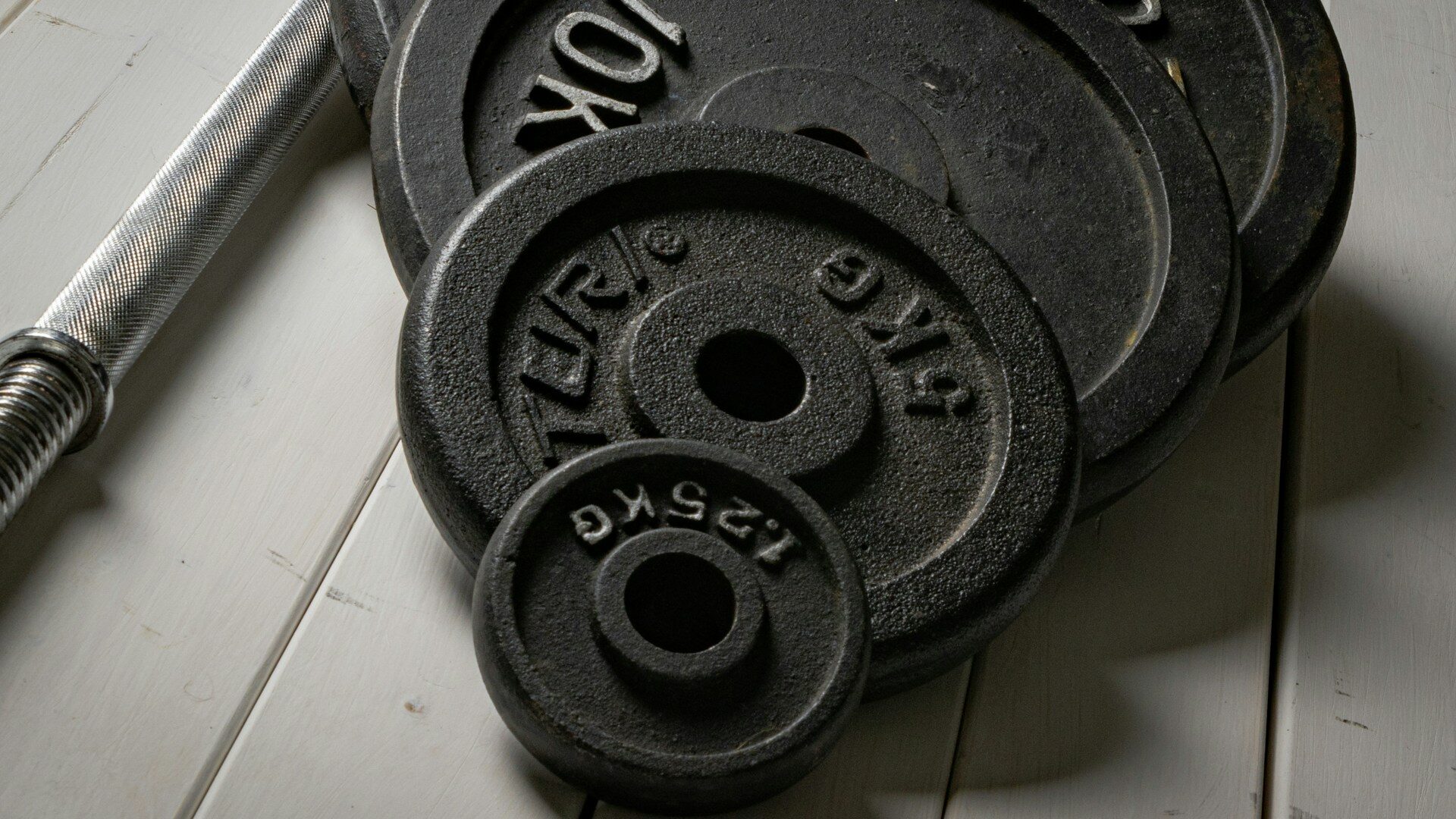 Stack of cast iron weight plates on a light wooden floor