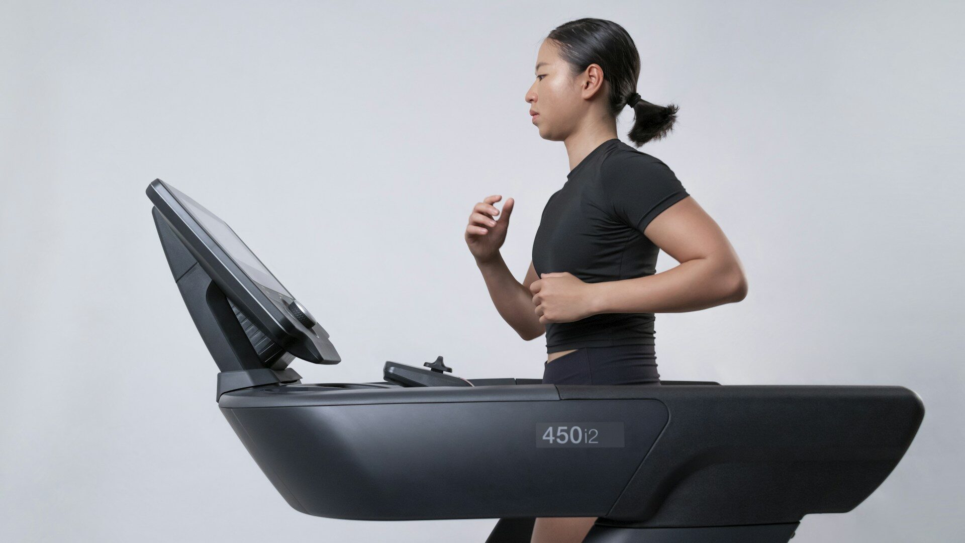 woman running on a treadmill in a bright studio Woman running on a treadmill in a bright studio
